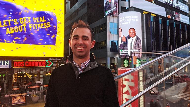 Matt Singh in front of NYC billboard