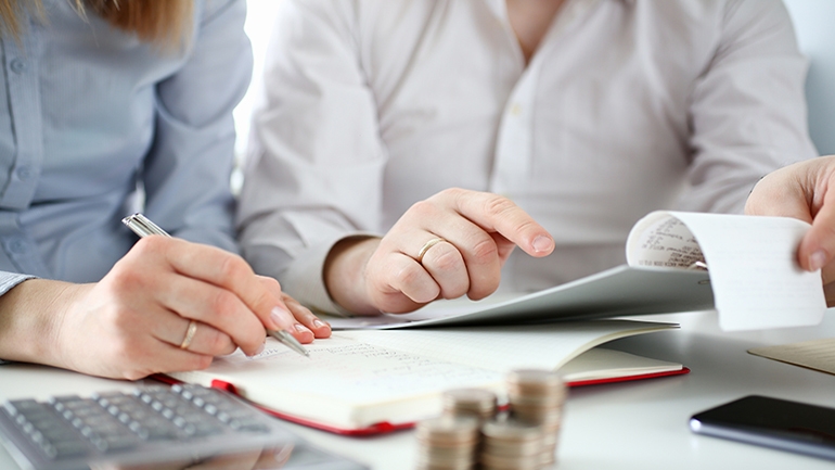 man and women sitting at table doing finances