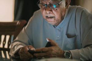 Elderly man looking at his phone
