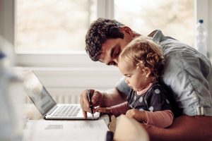 Young father working from home with child
